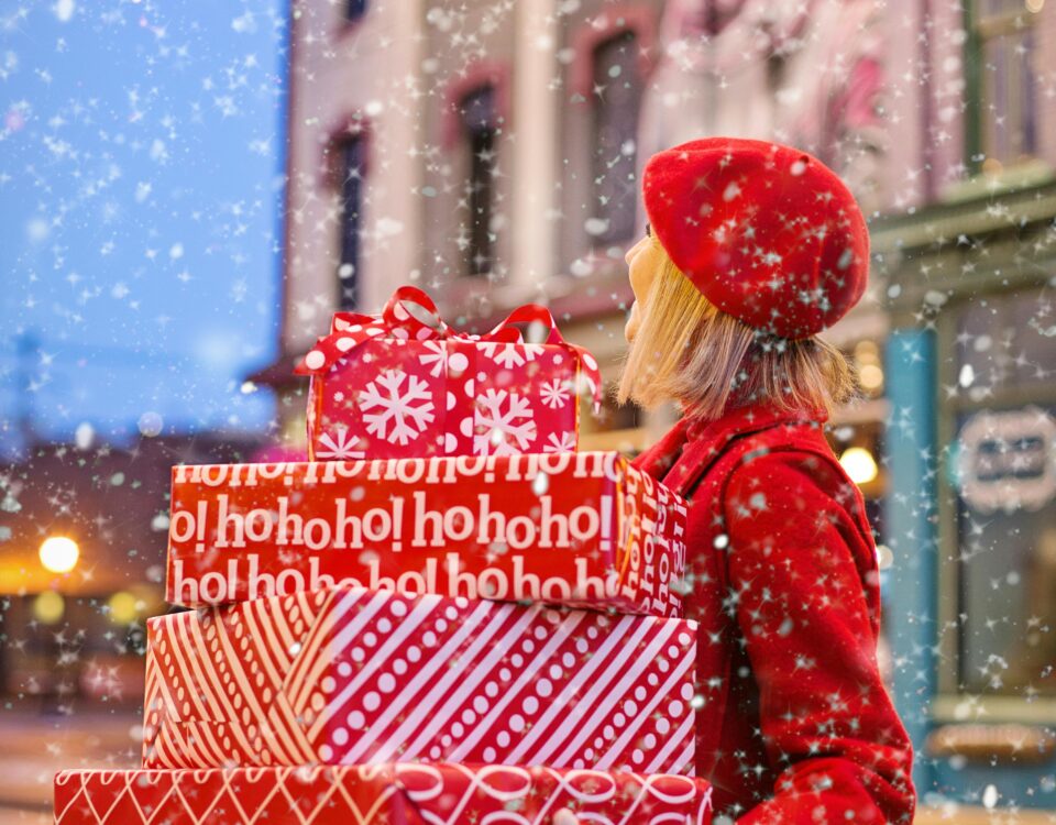 Woman in red carrying gifts while it's snowing